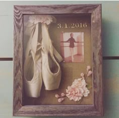 there is a picture frame with shoes and flowers on it