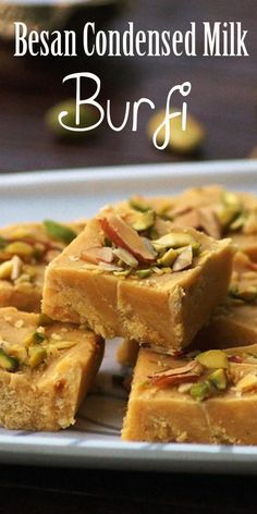 several pieces of cake sitting on top of a white plate with nuts and pistachio