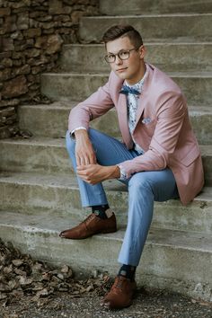 a man in a pink suit sitting on some steps