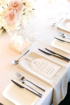 the table is set with silverware and place settings