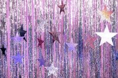 stars are hanging from the ceiling in front of pink and blue tinsel foils