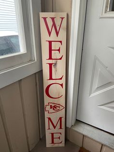 a wooden welcome sign sitting next to a door