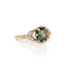 Named after the Norse goddess of love, our Freya ring has three diamond leaves on both sides of the center sapphire. It has color-changing blue-green sapphire that has a hint of purple under warm artificial lighting. About this ring: Made in 14k yellow gold About the center gem: ~2.05ct emerald cut eye clean parti color-changing sapphire Side diamonds: 0.18ctw round diamonds Color G-H Clarity SI1 This one-of-a-kind piece has been sold but we can create a similar one. This piece is made to order. Norse Goddess Of Love, Artificial Lighting, Norse Goddess, Blue Green Sapphires, Free Spirit Style, Goddess Of Love, Sapphire Diamond Ring, Green Sapphire, Sapphire Diamond