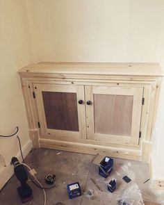 an unfinished entertainment center is being built in the corner of a room with tools on the floor