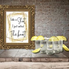 three shot glasses with lemon wedges in front of a framed poster that says, take a seat i just need the beat