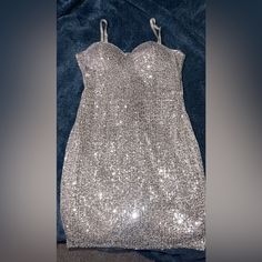 a silver sequined dress on a blue velvet background