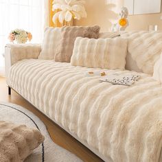 a living room with a white couch and pillows