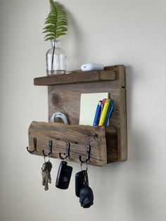 a wooden shelf with key hooks and keys hanging from it's sides on a wall