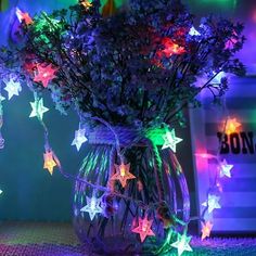 a vase filled with purple and green stars