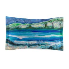 a blue and green pillow with an ocean scene on it