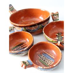 four orange bowls with designs on them sitting next to each other