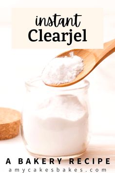 a wooden spoon filled with white icing next to a jar of cake mix on a table