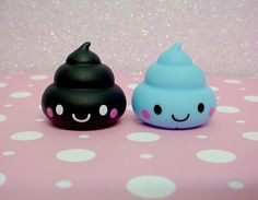 two small black and blue toys sitting on top of a pink table