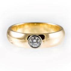 a yellow gold ring with a diamond in the center