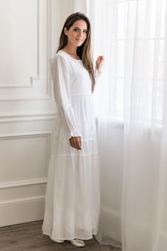 Long, white, light weight 100% cotton dress with button down front bodice and long sleeves. Embroidery on bodice, sleeves and hemline with 2 deep pockets on seam. This fully-lined, breathable dress has a slightly dropped empire waist and ties in the back for the perfect fit. Available in regular and petite lengths. Cold wash, drip dry. Sizes: XXS-2, XS-4/6, S-8/10, M-12/14, L-16/18, XL-20/22, 2XL-24, 3XL-26. Modest Cotton Maxi Dress For Daywear, White Peasant Dress For Daywear, White Cotton Maxi Dress With Broderie Anglaise, White Long Sleeve Peasant Dress For Daywear, White Full-length Maxi Dress For Spring, White Cotton Maxi Dress With Chikankari Embroidery, Modest White Dress With Lace Trim, Temple Dress Lds Endowment 2022, White Temple Dresses Long Sleeve