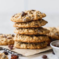 a stack of cookies sitting on top of a table next to a bowl of raisins