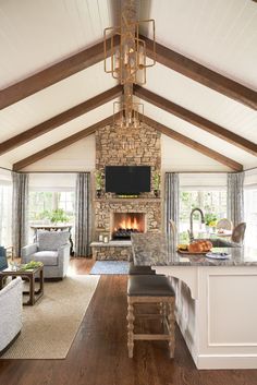 a living room filled with furniture and a fire place in the middle of a kitchen