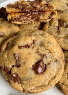 chocolate chip cookies are piled on top of each other in a white plate, with one cookie missing