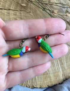 two parrots are sitting on top of each other in the palm of someone's hand