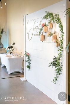 there are many potted plants on the wall in this room with tables and chairs