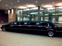 a black limousine parked in front of a building