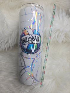 a white tumbler with the word volleyball painted on it next to a pencil