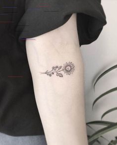 a small sunflower tattoo on the right arm