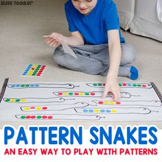 a young boy sitting on the floor playing with a pattern snakes game for toddlers