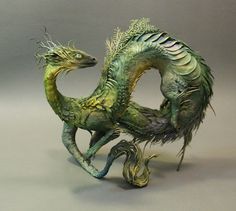 a statue of a green dragon on its hind legs and tail curled in the wind