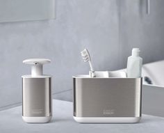 two toothbrushes and soap dispensers on a counter