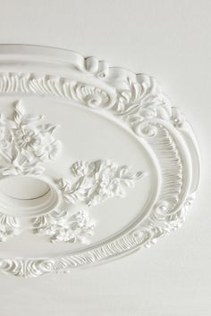 an ornate white ceiling medallion with flowers on it