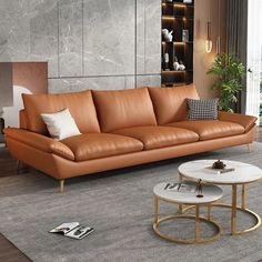 a brown leather couch sitting on top of a gray rug