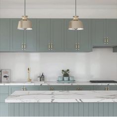 an image of a kitchen setting with marble counter tops and green cabinets in the background