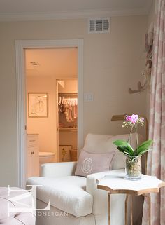 a living room with white furniture and pink curtains