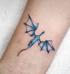 a blue dragon tattoo on the wrist