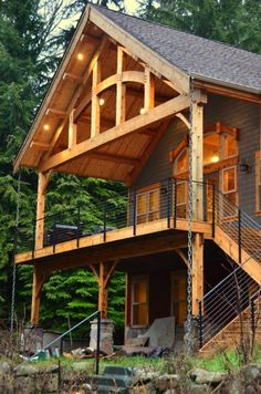 a large wooden house sitting on top of a lush green forest