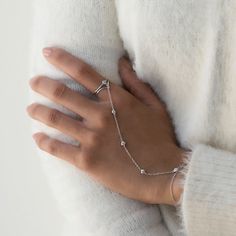 Dainty and minimal, but never understated. This handchain bracelet is made with five tiny pave crystals linked to a delicate chain that shimmers with every move. Comfortable to wear for long periods, you'll never want to take this off! Sterling Silver White Zirconia Crystals Wrist Chain Length: 5.75-6.75in (14.6-17cm), 6.75-7.75in (17-20cm) Palm Chain Length: 4in (10.2cm) Cubic Zirconia pave crystals, 3mm Handcrafted in NYC Hypoallergenic, lead and nickel free #B298 2-3 Business Days Delicate Chain Ring, Hands Full Of Bracelets, Classy Hand Rings, Hand Rings Simple, Cheap Elegant Hand Wrapped Jewelry, Hand For Jewelry, Rose Gold Stackable Rings, Wrist Chain, Hand Chain Jewelry