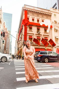 a woman in an orange dress crossing the street