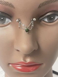 a mannequin's face with chain and nose ring