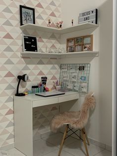 a desk and chair in a room with geometric wallpaper on the walls, along with shelves