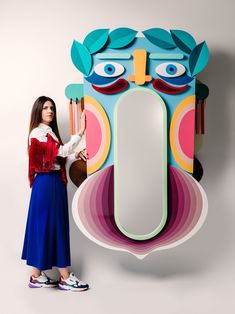 a woman standing in front of a paper cut out of an owl's head