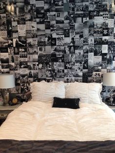 a bed with white sheets and pillows in front of a black and white photo wall