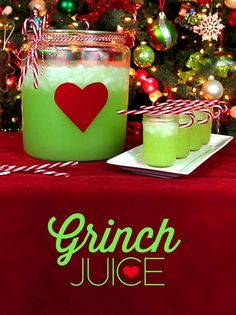 green juice in a glass jar next to a christmas tree with candy canes on it