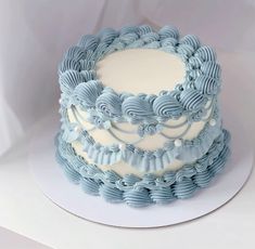 there is a blue and white cake with icing on the top that looks like waves