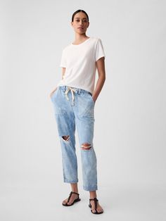 Fit: Pull-on jeans with an elastic waistband & easy, relaxed leg.  Fabric: 95% Cotton, 5% Recycled Cotton.  Stretch: No Stretch Jeans.  Authentic denim that gets better with every wear.  Made to wear all day & break in over time. ​ Rise: Mid Rise Jeans.  Look: A distressed four-pocket jean in a light indigo wash.  Raw, cuffed hem can be unrolled.  Details: Elasticized waist with drawcords & four-pocket styling.  Responsibly Made: This pair of jeans is part of our water-saving Washwell program. Utility Jeans, Corduroy Leggings, High Rise Blue Jeans, Gap Jeans Women, Jeans Look, Womens Camo, Pull On Jeans, Water Saving, Relaxed Jeans