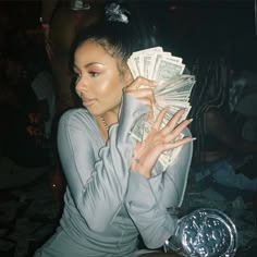 a woman sitting on the floor with money in her hands