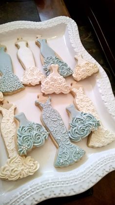 decorated cookies in the shape of peacocks on a white platter with lace trim