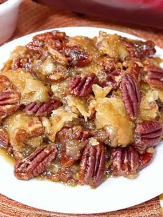 a plate with pecans on it next to a bowl of nuts