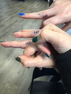 two people with different colored nails and numbers on their fingers