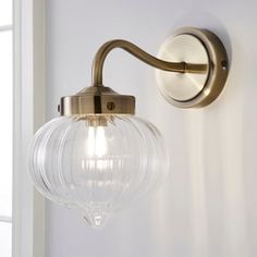 a glass globe light hanging from the side of a wall